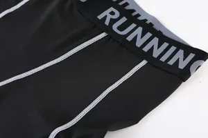 Macro view showing high-quality flatlock stitching on kids' black compression pants