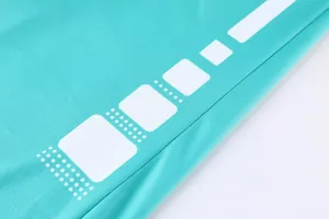 Gros plan du tissu en maille respirante sur le maillot de basket turquoise avec motifs.