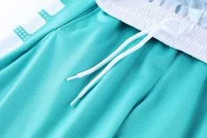 Vue détaillée d'un short de basket turquoise avec cordon blanc et taille élastique
