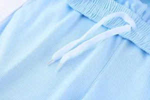 Detail view of breathable mesh fabric and drawstring on light blue athletic shorts