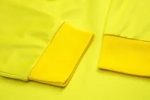 Dettaglio ravvicinato della maglia da portiere gialla in mesh traspirante e polsini