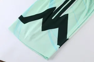 Dettaglio del tessuto traspirante della maglia da basket verde menta con motivo a zigzag verde