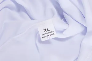 Dettaglio dell'etichetta di un gilet sportivo bianco in poliestere, taglia XL