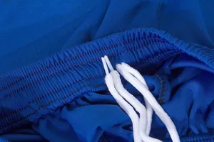 Dettaglio dei pantaloncini da calcio blu con rete traspirante e coulisse in vita