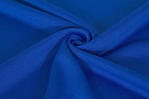 Dettaglio macro del tessuto a rete traspirante blu reale per maglie da calcio