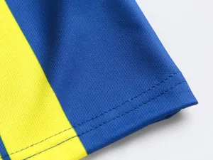 Detailaufnahme von atmungsaktivem Mesh-Gewebe und Doppelsaum an einem gelb-blauen Trikot.