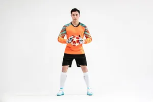 Vue complète d'un gardien de but portant un ensemble de football orange à manches longues
