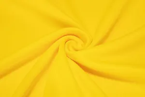 Vue macro montrant la texture en maille jaune respirante du tissu de maillot de sport
