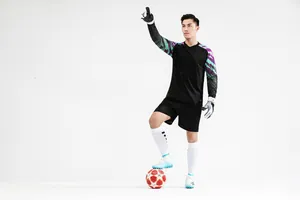 Professional black goalkeeper uniform set with patterned sleeves shown on male model