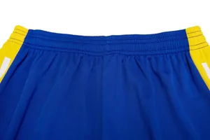 Détail de la ceinture élastique sur un short de football bleu et jaune pour l'entraînement.