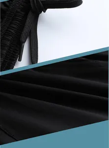 Macro detail view of unisex black sports shorts showing drawstring and fabric texture.