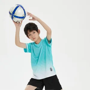 Boy wearing a cyan gradient quick-dry football jersey set holding a soccer ball