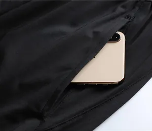 Close-up of black unisex sports shorts featuring a deep side pocket with a smartphone inside