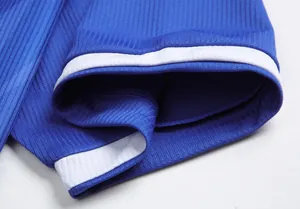 Detailansicht des blauen Rippenstoffes und des weißen Ärmelbündchens am Trikot.