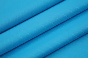 Κοντινή λήψη μακροεντολής αναπνεύσιμου γαλάζιου υφάσματος φανέλας ποδοσφαίρου με διαγώνια υφή.