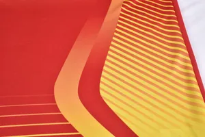 Gros plan du maillot de gardien de foot rouge avec mesh respirant à dégradé jaune