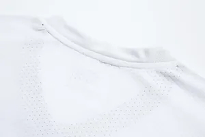 Vue macro du tissu technique en maille respirante blanche sur col de maillot
