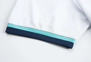 Détail de la manche d'un maillot de football blanc respirant avec bordure bleue