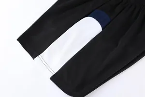 Close-up of breathable mesh fabric on black sports shorts featuring white stripe detail