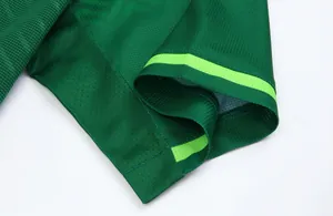 Macro view of green football jersey sleeve edge with vibrant neon stripe details
