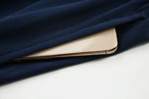 Gros plan de la poche d'un maillot de foot bleu marine respirant avec smartphone