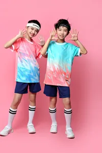 Two children modeling vibrant soccer jerseys with geometric patterns and shorts.