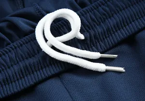 Gros plan montrant la taille élastique et le cordon de serrage blanc d'un short de foot bleu marine