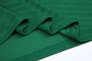 Close-up detail of green breathable waffle texture fabric for sport football jersey.