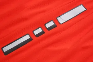 Close-up detail of reflective stripes on breathable red mesh basketball jersey fabric.