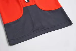 Close-up of breathable mesh fabric and double-stitched hem on a red basketball jersey.