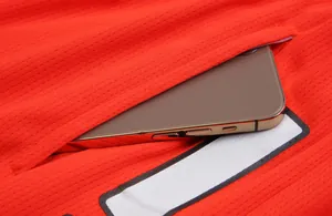 Detailed close-up view of red basketball jersey pocket with smartphone storage space