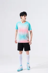 Full view of male athlete in blue and pink gradient soccer jersey and black shorts set