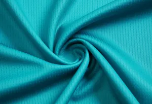 Detalle de textura macro de tejido sintético verde azulado transpirable para camisetas