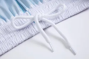 Primer plano del cordón blanco y la cintura elástica de un pantalón de baloncesto a rayas