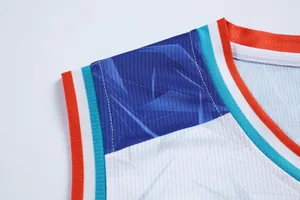 Primo piano della spalla di una maglia da basket traspirante con motivi geometrici blu.