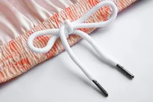 Nahaufnahme des weißen Kordelzugs am orangefarbenen elastischen Bund der Basketballshorts