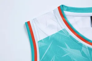 Dettaglio della spalla di una maglia da basket con motivi geometrici turchesi.