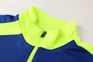 Detailansicht des Stehkragens und Reißverschlusses der neongelben Fußball-Trainingsjacke
