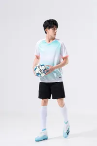 Professional men's soccer jersey in white to light blue gradient with v-neck and black shorts.
