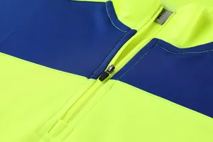 Detailaufnahme von Reißverschluss und Kragen an neon-gelber und blauer Trainingsjacke.