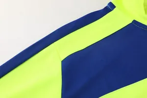 Detailansicht der präzisen Nähte an einer blau-neongelben Fußball-Trainingsjacke