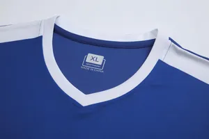 Close-up of blue soccer jersey V-neckline with white trim and printed size tag