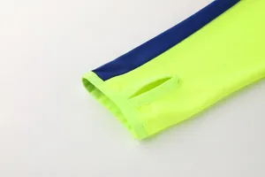Nahaufnahme des Daumenlochbündchens an einer neongelben und blauen Sport-Trainingsjacke
