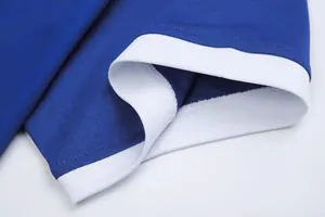Close-up of blue football jersey detail showing breathable mesh fabric and white trim