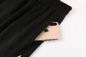 Detailaufnahme der funktionalen Reißverschlusstasche an der schwarzen Fußballjacke
