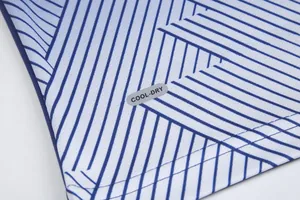 Close-up detail of soccer jersey fabric with blue geometric stripes and COOL-DRY label