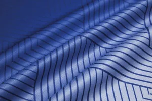 Close-up of blue soccer jersey fabric showing breathable mesh texture and geometric pattern