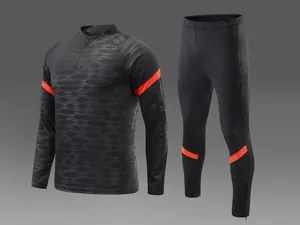 Vue détaillée du survêtement de football noir avec rayures orange et motifs ondulés