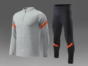 Gros plan d'un ensemble de survêtement de football gris et noir avec détails orange
