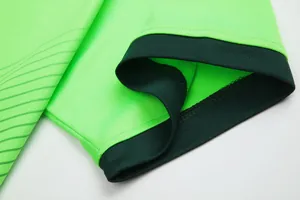 Close-up of fluorescent green soccer jersey sleeve with dark green ribbed cuff detail.